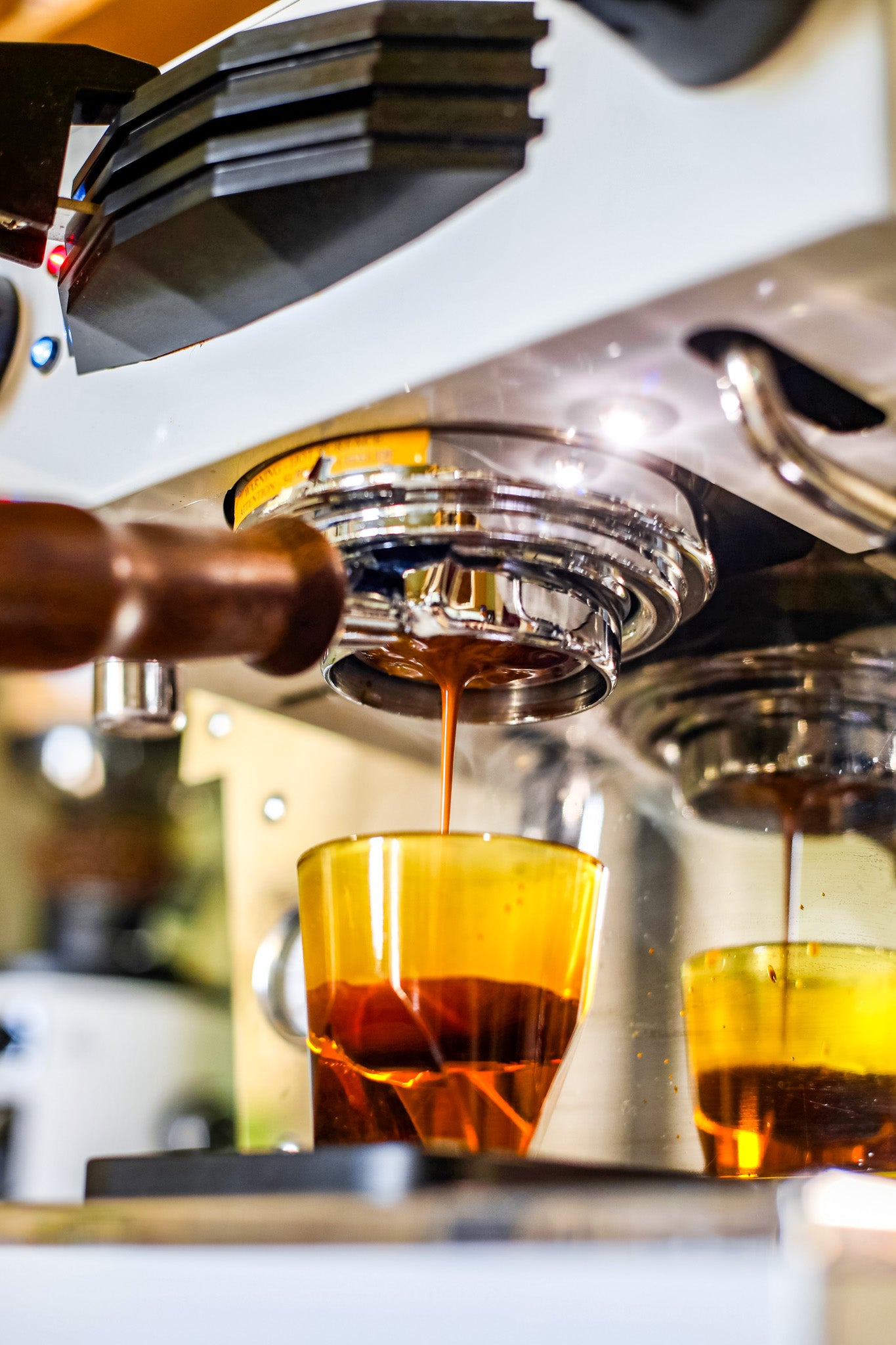 Espresso being poured into a glass from an espresso machine.